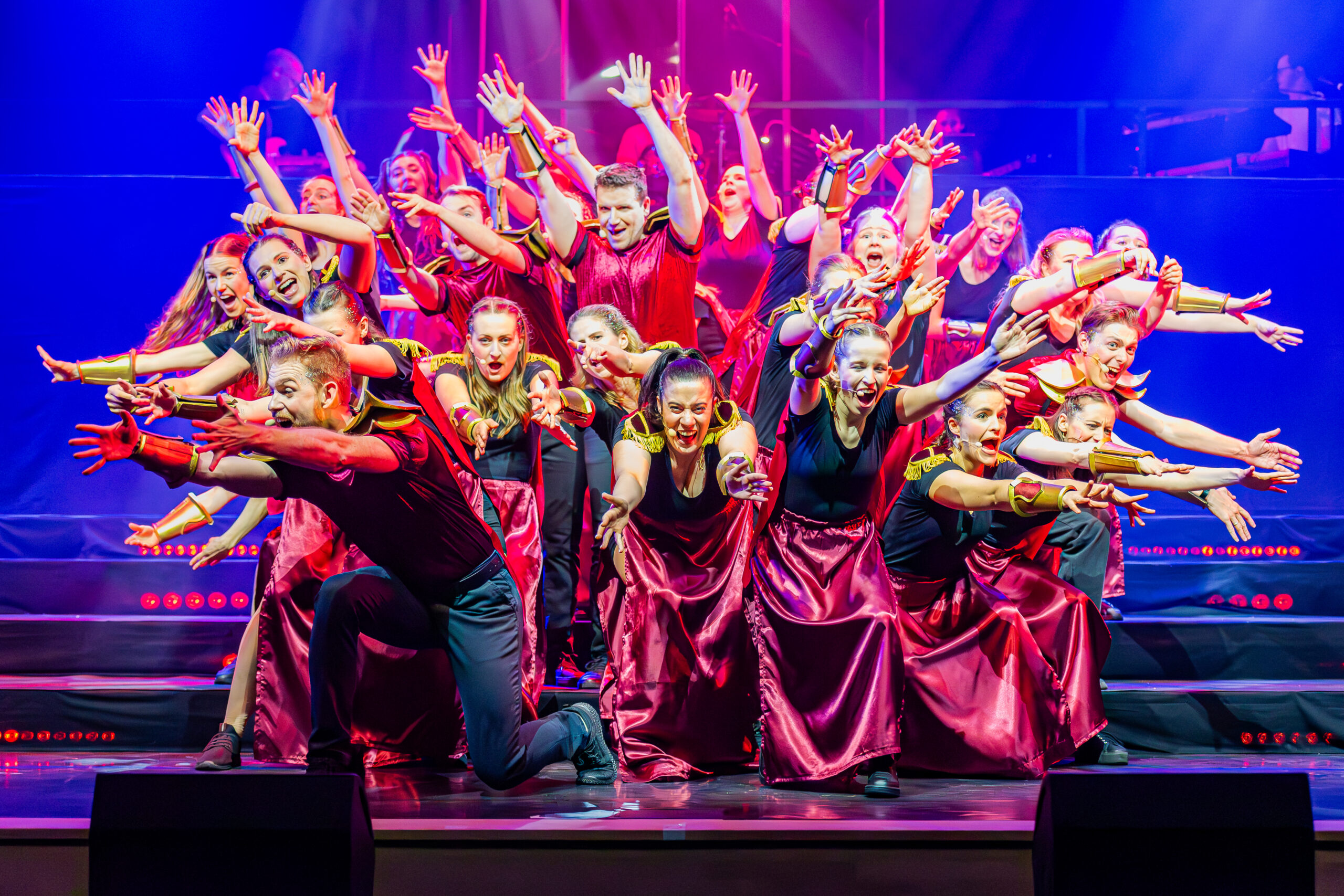 Koorleden dansen en zingen op het podium